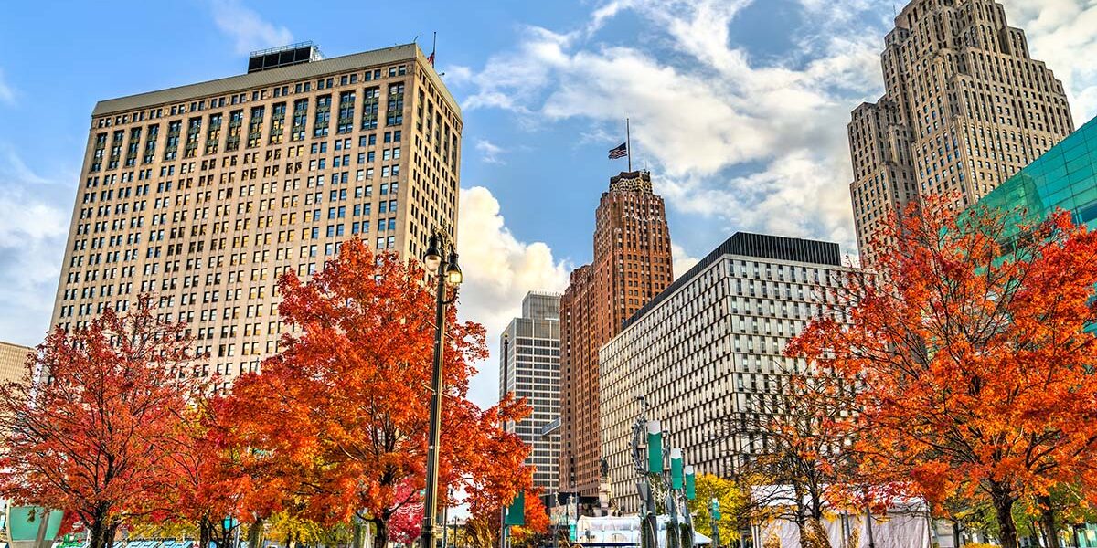 Historic buildings in Downtown Detroit, Michigan on a bright, clear Fall day with a blue sky and fluffy clouds.